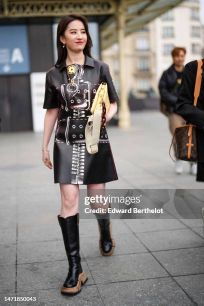 Liu Yifei wears gold pendant earrings, a black shiny leather with white and red painted pattern short sleeves / shirt neck / short leather dress from...