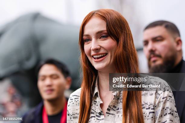 Sophie Turner wears a white with black musical notes print pattern shirt, outside Louis Vuitton, during Paris Fashion Week - Womenswear Fall Winter...