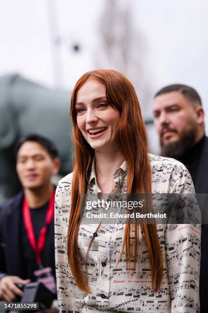 Sophie Turner wears a white with black musical notes print pattern shirt, outside Louis Vuitton, during Paris Fashion Week - Womenswear Fall Winter...