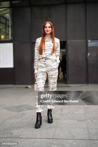 Sophie Turner wears a white with black musical notes print pattern shirt, matching white with black musical notes large pants, a beige Epi leather...