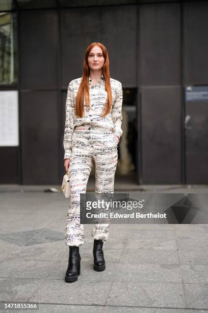Sophie Turner wears a white with black musical notes print pattern shirt, matching white with black musical notes large pants, a beige Epi leather...