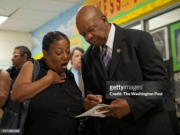 Rep. Elijah E. Cummings, D-MD, autographs a photograph for Roslyn Gomez at Woodlawn Senior High School in Gwynn Oak, Maryland on June 16, 2012....