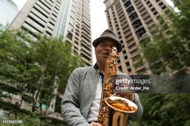 profitez d’une retraite anticipée.profitez d’un moment de détente en ville, profitez de la musique et de la famille heureux avec de bons amis - saxaphone portrait photos et images de collection