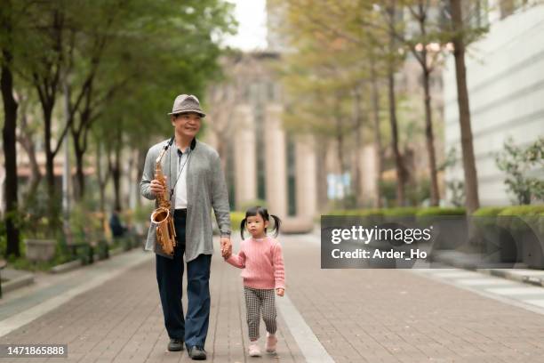 enjoying early retirement.enjoy a leisurely moment in the city, enjoy music and family happily with good friends - asian musician stock pictures, royalty-free photos & images