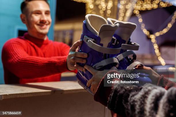 joven alquilando un par de patines de hielo - ice skating pair fotografías e imágenes de stock