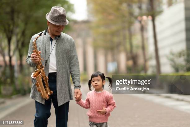 enjoying early retirement.enjoy a leisurely moment in the city, enjoy music and family happily with good friends - asian musician stock pictures, royalty-free photos & images