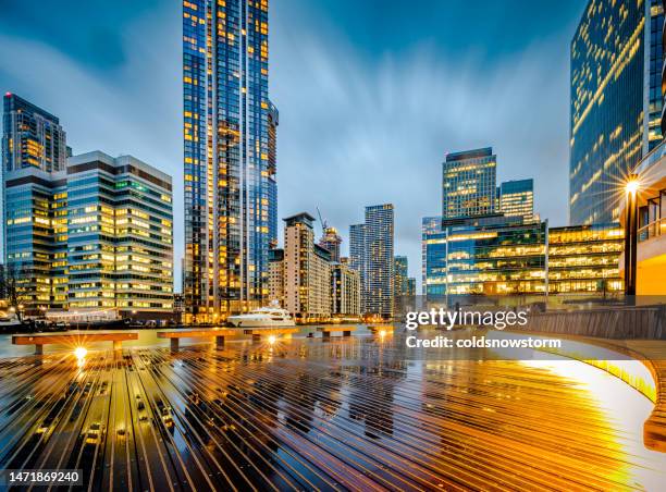 futuristic architecture of london financial district illuminated in early evening - sunset on canary wharf stock pictures, royalty-free photos & images