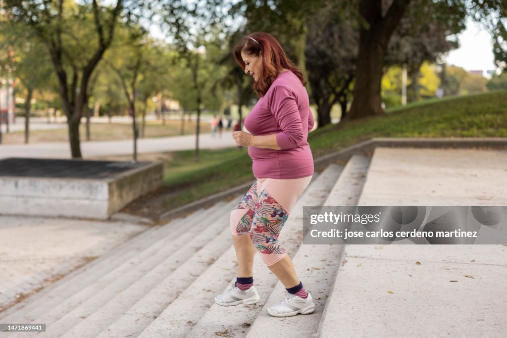 Overweight mature woman does sports to take care of her heart, healthy life, plus size, big woman.