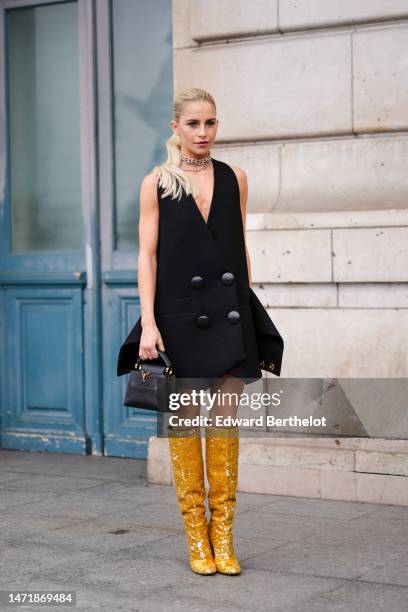 Caroline Daur wears gold and silver diamonds large necklaces from Tiffany, a gold and diamonds necklace, a black V-neck / sleeveless / large...