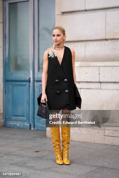 Caroline Daur wears gold and silver diamonds large necklaces from Tiffany, a gold and diamonds necklace, a black V-neck / sleeveless / large...