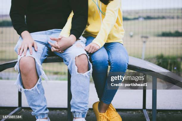 young teenage couple in a public park - casal adolescente imagens e fotografias de stock