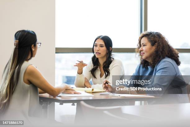 two female business partners interview mid adult woman - serious interview stock pictures, royalty-free photos & images