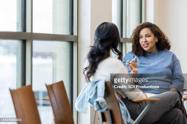 unrecognizable female client listens as female counselor gives advice - information imagens e fotografias de stock