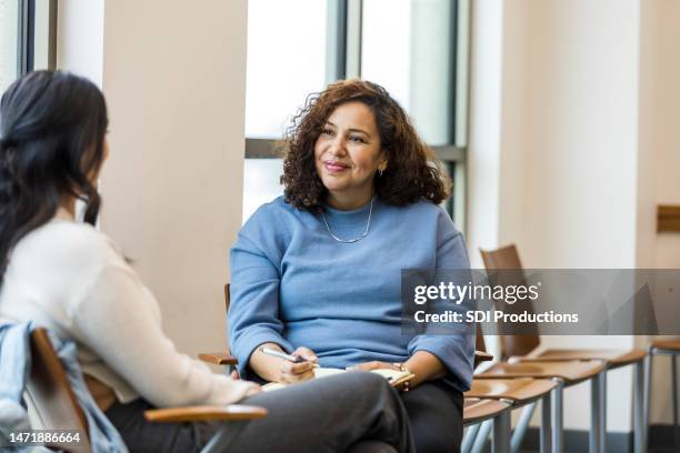 female human resources rep smiles encouragingly at female employee - empathetic listening stock pictures, royalty-free photos & images