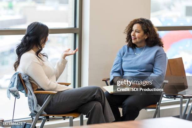 female client gestures and explains her problems to female counselor - employee review imagens e fotografias de stock