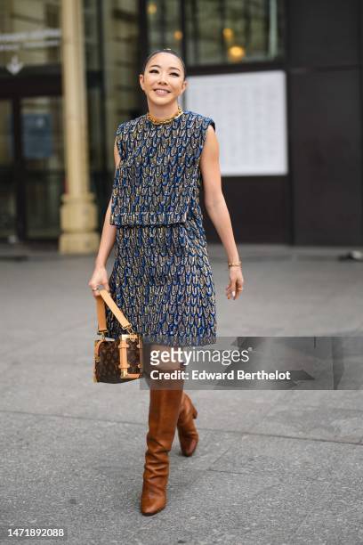 Guest wears a royal blue / black / gold shiny embossed leather pattern sleeveless knees dress from Louis Vuitton, a brown LV monogram print pattern...