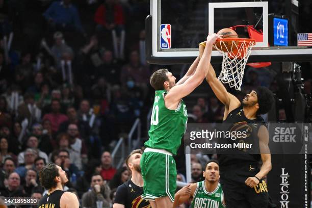 Luke Kornet of the Boston Celtics dunks over Jarrett Allen of the Cleveland Cavaliers during the third quarter at Rocket Mortgage Fieldhouse on March...