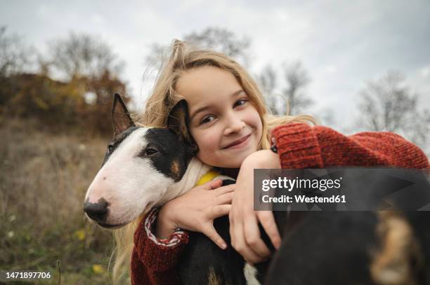 smiling cute girl embracing dog - bull terrier stock pictures, royalty-free photos & images