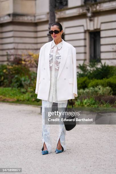 Guest wears brown sunglasses from Celine, gold earrings, a white tulle with embroidered sequined and leather pattern buttoned shirt, matching white...