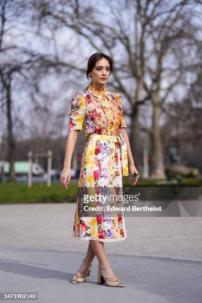 Guest wears a white with multicolored flower print pattern shirt neck / short sleeves / belted midi dress, green sunglasses, beige matte leather with...
