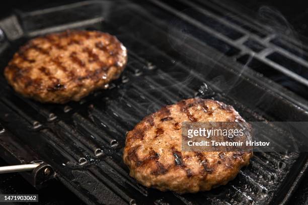 a top view of baking a burger on a grill pan in the kitchen. - burgers cooking grill stockfoto's en -beelden