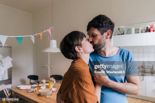 affectionate couple kissing each other at home - kissing mouth stock pictures, royalty-free photos & images