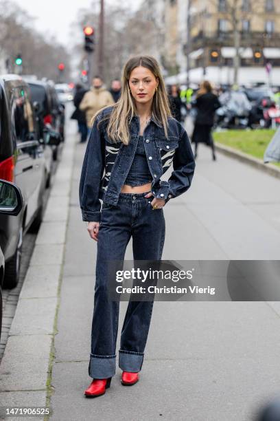 Guest wears cropped denim top, jacket, cuffed jeans, red boots outside Stella McCartney during Paris Fashion Week - Womenswear Fall Winter 2023 2024...