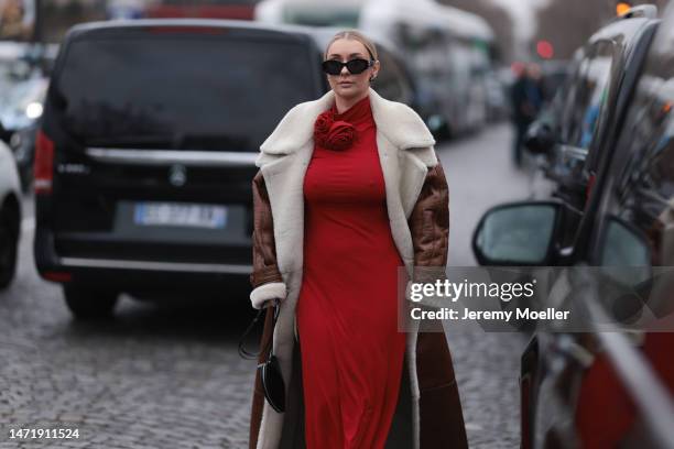 Justyna Czerniak wears a red dress, brown shearling fur coat, black Alaia bag, outside Stella McCartney during Paris Fashion Week - Womenswear Fall...