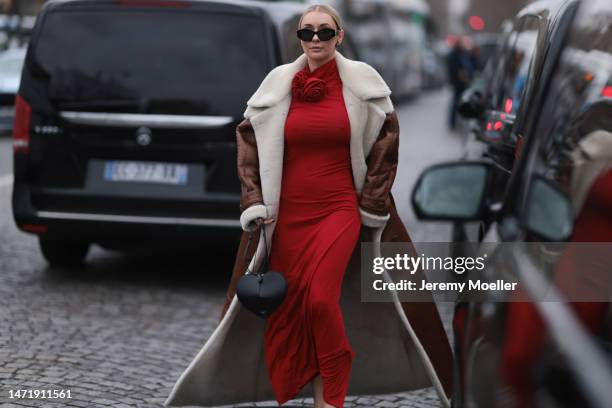 Justyna Czerniak wears a red dress, brown shearling fur coat, black Alaia bag, outside Stella McCartney during Paris Fashion Week - Womenswear Fall...