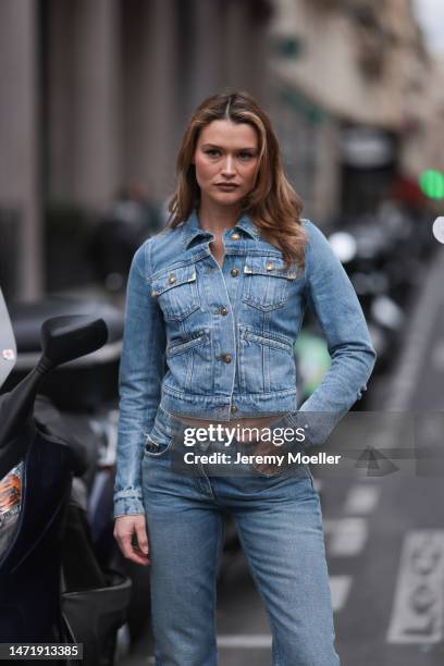 Chloe Lecareux wears a blue denim jeans jacket, a blue mom jeans with a pocket detail, outside before Palm Angels Show, during Paris Fashion Week on...