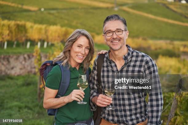 mature couple holding wineglasses on hill - rheingau stock pictures, royalty-free photos & images