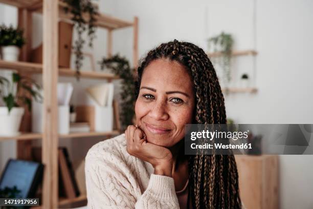 smiling freelancer with hand on chin at home office - hand on chin stock pictures, royalty-free photos & images