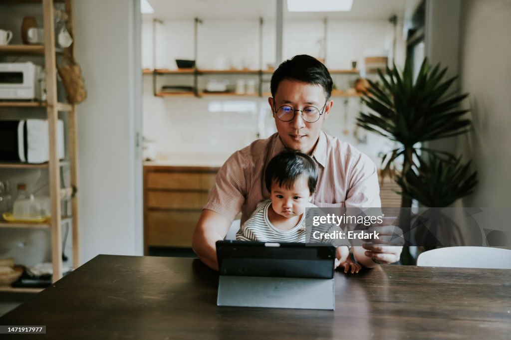Père célibataire asiatique payant sur la boutique en ligne avec carte de crédit.