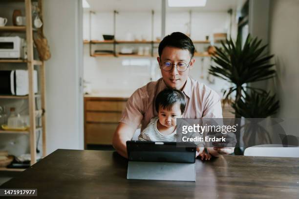 padre single asiatico che paga sul negozio online con carta di credito. - asian family shopping foto e immagini stock