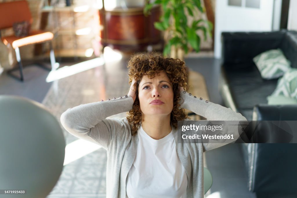 Frustrated freelancer with head in hands at home