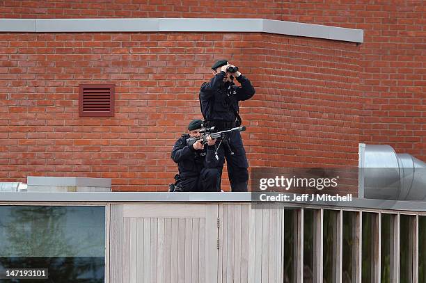 Police sniper and spotter look out from the top of the roof of the Lyric Theatre as they wait for Britain's Queen Elizabeth II and Prince Philip,...