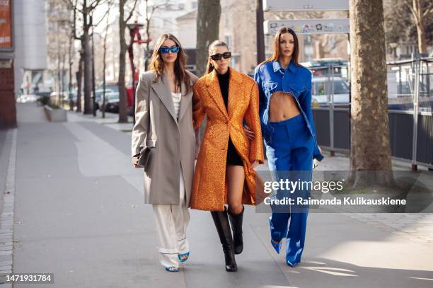 Mari Fonseca is seen wearing hwite pants, white top, grey coat and blue sunglasses, and Fer Millan Delaroiere is seen wearing black boots, black mini...