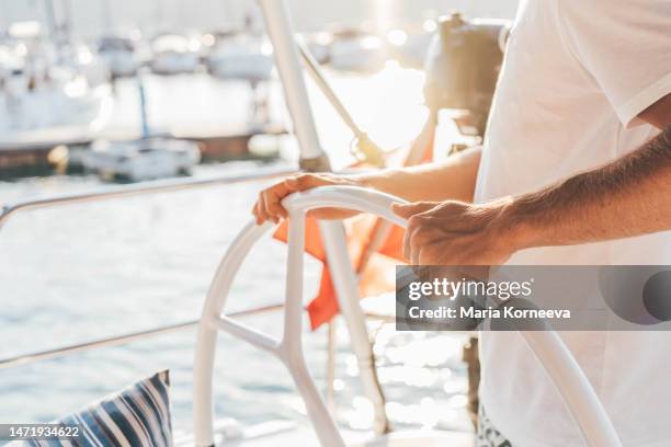 man driving a yacht. - rudder stock pictures, royalty-free photos & images