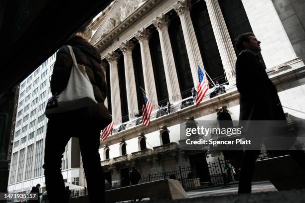 People walk by the New York Stock Exchange in the Financial District on March 07, 2023 in New York City. Stocks fell in early trading on Tuesday...