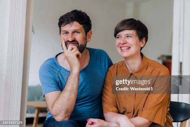 smiling man with hand on chin by woman at home - hand on chin stock pictures, royalty-free photos & images