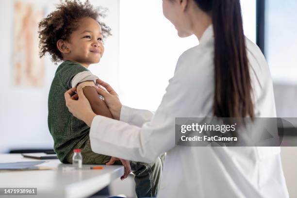boy receiving a vaccination - kinderarts stockfoto's en -beelden