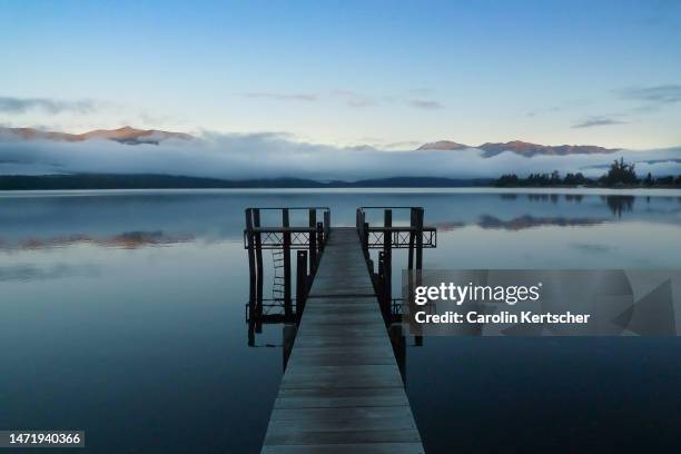 boat dock at lake te anau at sunrise | new zealand - te anau stock pictures, royalty-free photos & images