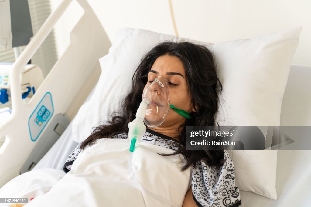 Woman with Ventilator mask on Hospital bed
