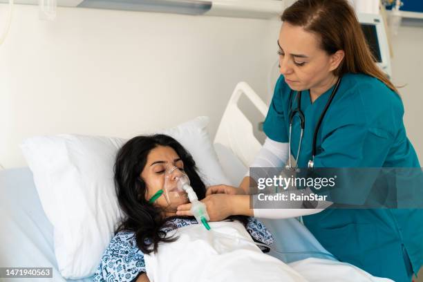 physician adjusting respiratory support at hospital - er visit stock pictures, royalty-free photos & images