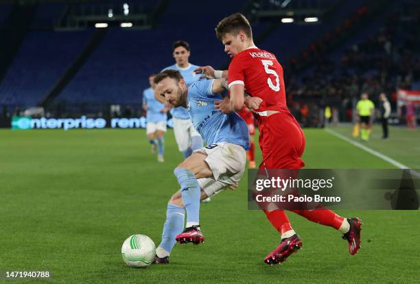Manuel Lazzari of SS Lazio clashes with Milos Kerkez of AZ Alkmaar during the UEFA Europa Conference League round of 16 leg one match between SS...