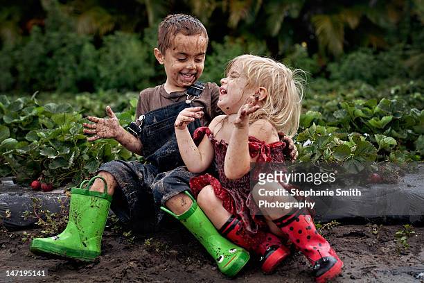 little boy and girl playing - schmutzig stock-fotos und bilder