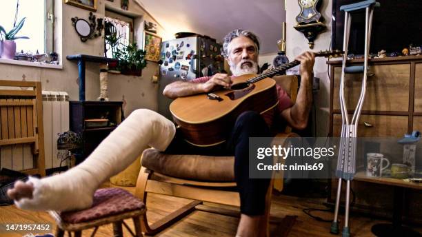man with an injured leg in a cast - male musician stock pictures, royalty-free photos & images