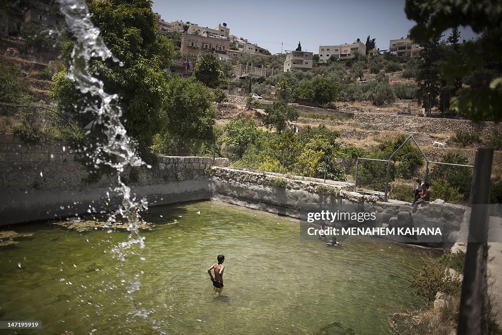 Palestinian children swim in the ancient