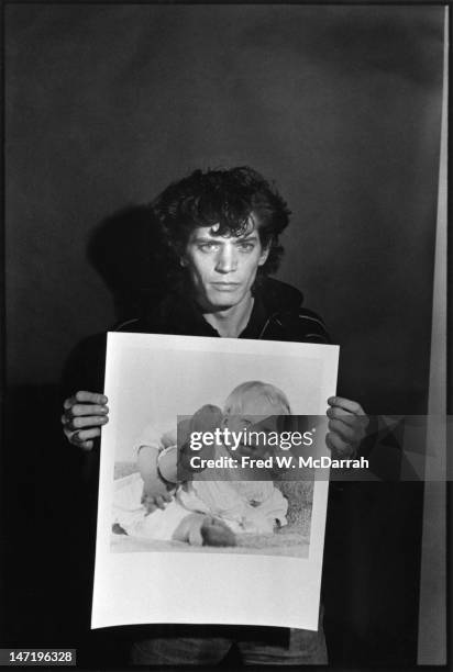 Portrait of American photographer as he poses with one of his photos in his loft studio , New York, New York, December 22, 1979.