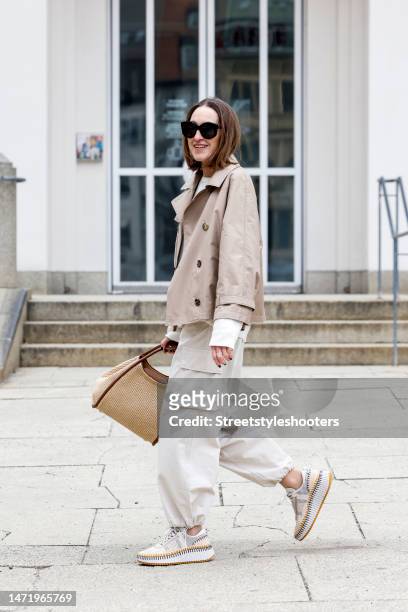 Influencer and style icon Annette Weber, wearing beige cargo pants by Second Female, a dark beige trench jacket by Max Mara, a white cashmere...